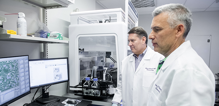 Two men in lab looking at computer